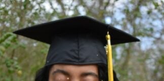 woman wearing mortarboard blowing sand
