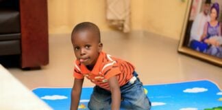 boy playing chevrolet camaro toy on floor