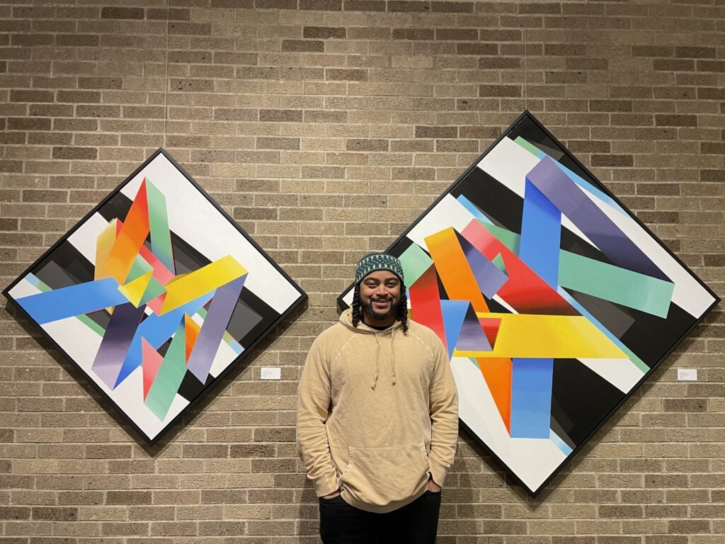 Israel Solomon stands in front of his work at the Harrison Center