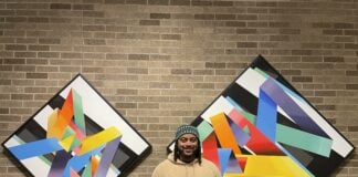 Israel Solomon stands in front of his work at the Harrison Center