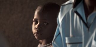 boy standing beside person