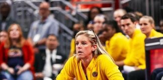 coach kneeling during WNBA game.