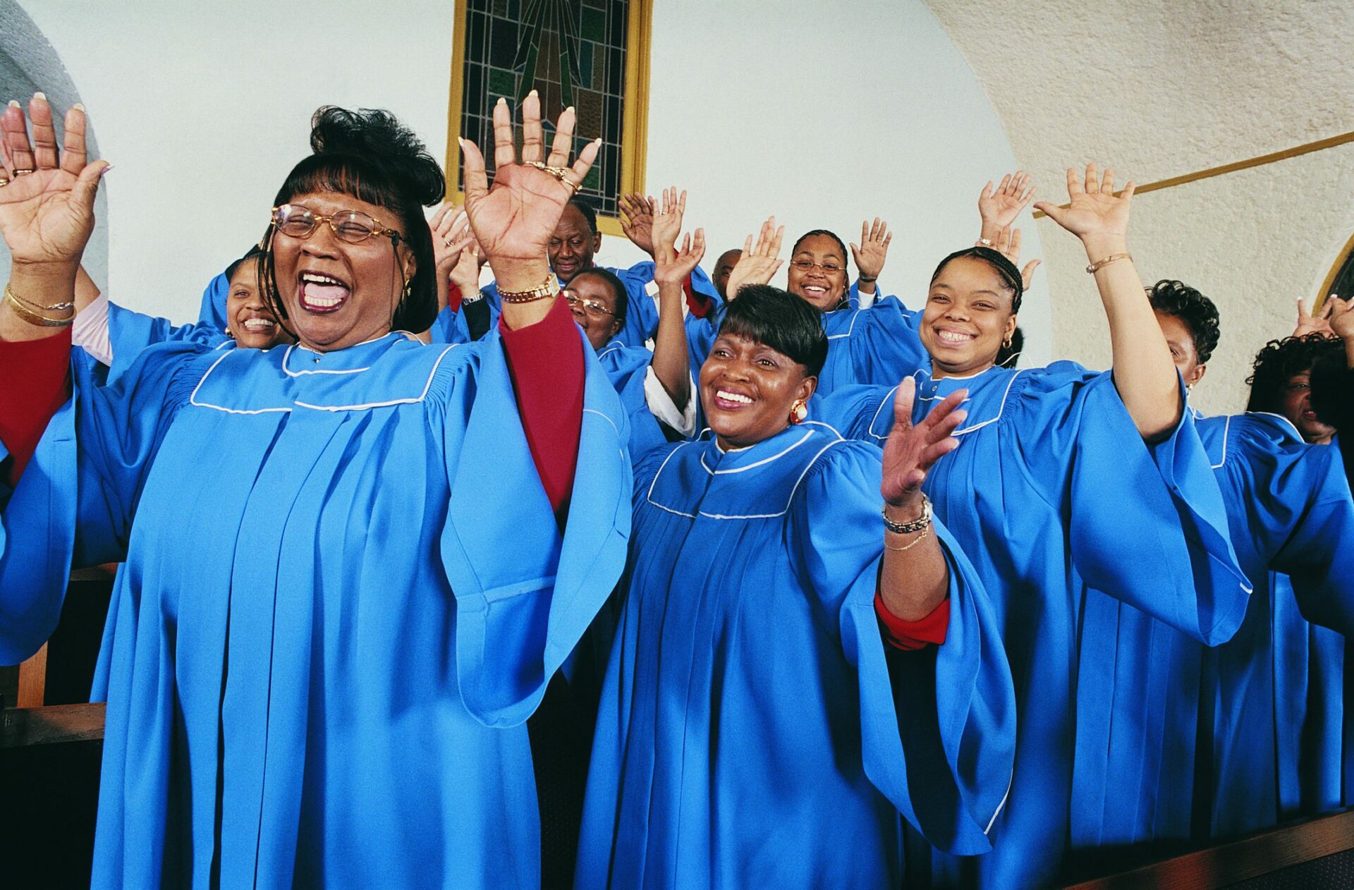 Twelve Gospel Singers With Raised Hands Singing in a Church Service Black people at church praising.