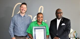 two man and woman pose with award