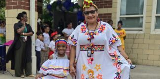 young student from Global Prep Academy stands with her teacher in cultural garb