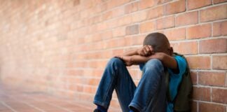 boy sitting alone after being bullied