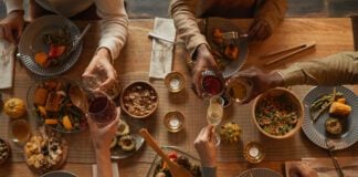 Above view background of multi-ethnic group of people enjoying feast during dinner party with friends and family