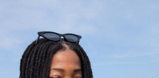 woman smiling at flower