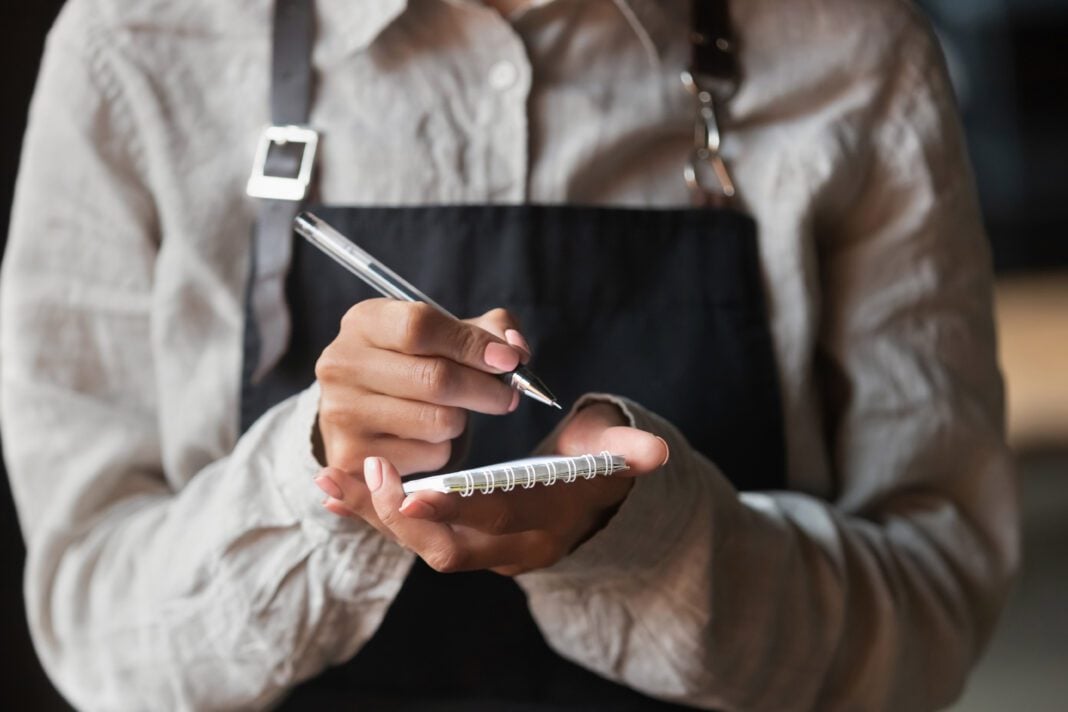 Waitress writing taking order serving customer in cafe