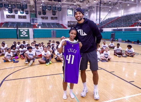 Trey Lyles and young fan during his free NBA youth basketball camp in Indianapolis, Indiana at Arsenal Technical High School in June of 2025.