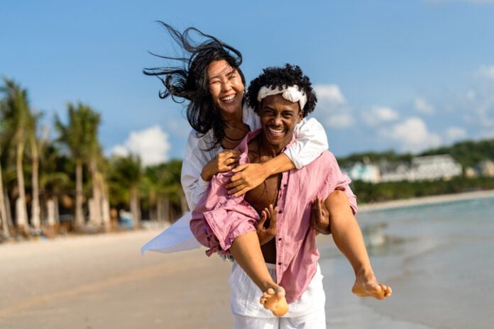 Interracial couple enjoying a romantic beach getaway, embracing love, laughter, and togetherness The second annual Loving Day celebration occurs from 1-3 p.m. on June 7 at Gainbridge Fieldhouse. (Photo/Getty Images)