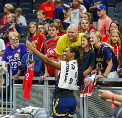 The young WNBA fan completes her checklist, taking a photo with Fever forward Aliyah Boston (7) following the team's loss to the Los Angeles Sparks on July 5, 2025 at Gainbridge Fieldhouse, in downtown Indianaplis, Indiana. (Photo/David Dixon)