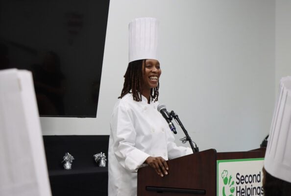 Second Helpings Culinary Job Training Graduate Britney Cole takes the podium to make remarks about her experience in the program on graduation day.