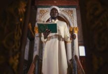 Democracy is ordained by Allah islam imam with koran book on hand making speech in isramic worship ceremony in mosque